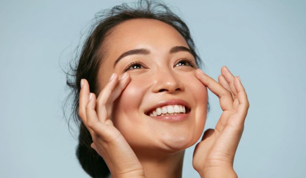a woman touching under her eyes smiling