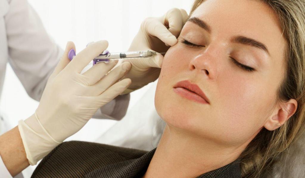 A young woman getting a filler injection.